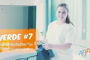 Junge Frau in Arbeitskleidung mit Reinigungsgerät in einem Raum.
