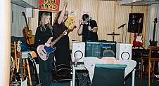 Junge Band probt in einem Raum mit Instrumenten.